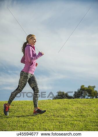 Stock Photo - Woman running through lawn. Fotosearch