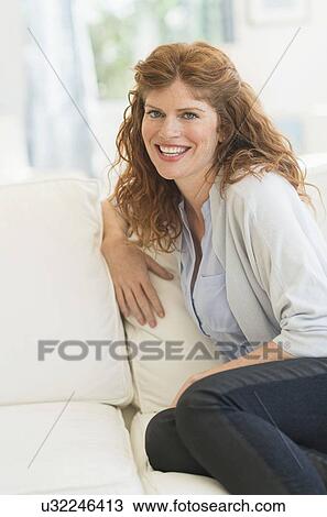 Woman sitting on sofa View Large Photo Image Stock Image - Woman sitting on sofa. Fotosearch