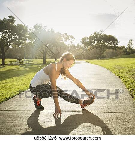Woman stretching in park View Large Photo Image Stock Photograph - Woman stretching in park. Fotosearch