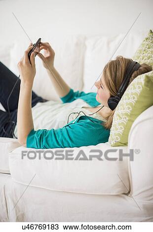 Stock Image - Woman watching movie on smart phone. Fotosearch