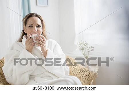 Woman wearing bathrobe drinking tea View Large Photo Image Stock Photograph - Woman wearing bathrobe drinking tea. Fotosearch