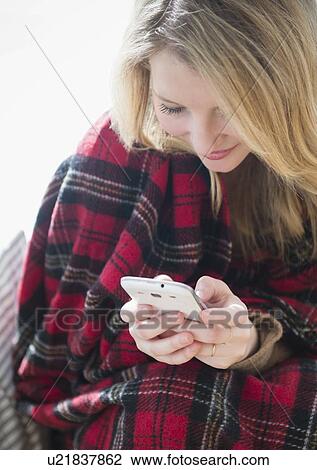 Woman wrapped in blanket text messaging View Large Photo Image Stock Image - Woman wrapped in blanket text messaging. Fotosearch