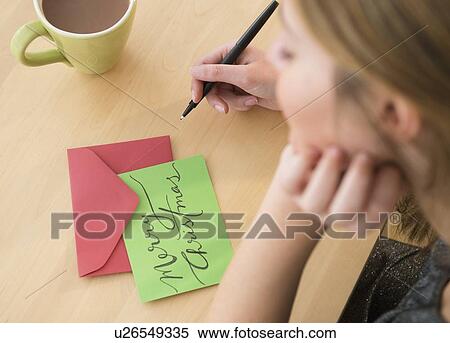 Stock Photography - Woman writing greeting card at christmas. Fotosearch