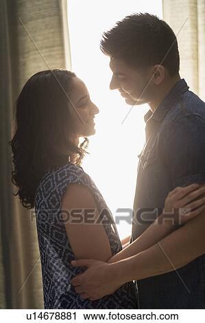 Stock Image - Young couple embracing in sunlight. Fotosearch