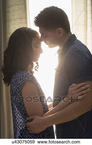 Young couple embracing in sunlight View Large Photo Image Stock Photo - Young couple embracing in sunlight. Fotosearch
