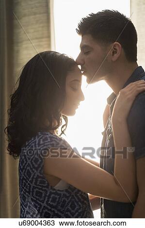 Young couple kissing in sunlight View Large Photo Image Stock Image - Young couple kissing in sunlight. Fotosearch
