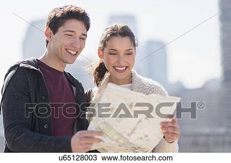 Stock Image - Young couple looking at map. Fotosearch
