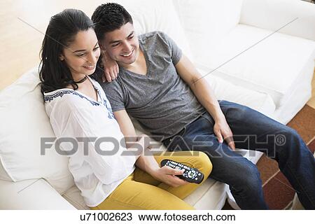 Young couple watching tv on sofa View Large Photo Image Stock Image - Young couple watching tv on sofa. Fotosearch