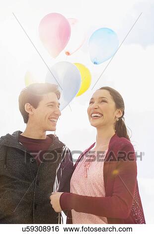 Stock Photograph - Young couple with balloons. Fotosearch