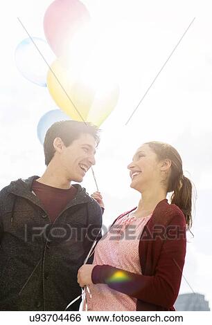 Young couple with balloons View Large Photo Image Stock Photograph - Young couple with balloons. Fotosearch