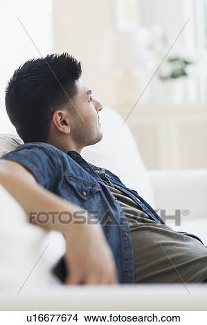 Young man relaxing on sofa View Large Photo Image Picture - Young man relaxing on sofa. Fotosearch