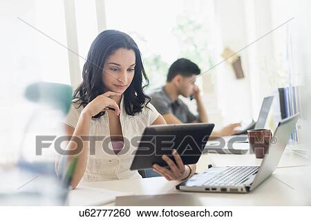 Young woman and man working in office View Large Photo Image Stock Image - Young woman and man working in office. Fotosearch