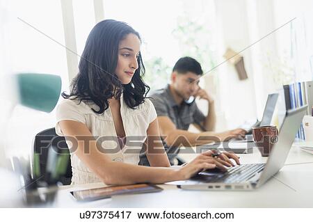 Young woman and man working in office View Large Photo Image Stock Photo - Young woman and man working in office. Fotosearch