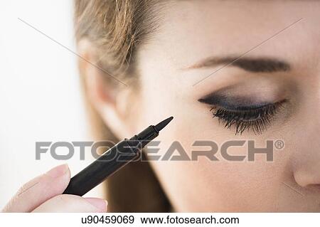 Young woman applying eyeliner View Large Photo Image Stock Photo - Young woman applying eyeliner. Fotosearch