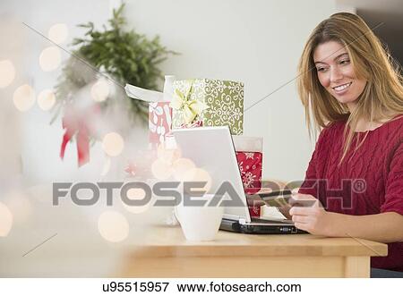 Stock Photo - Young woman doing online shopping. Fotosearch