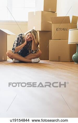 Picture - Young woman during moving into new house. Fotosearch