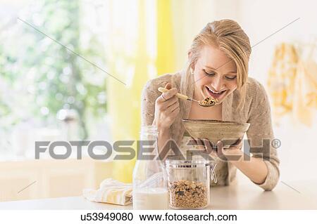 Young woman eating granola for breakfast View Large Photo Image Stock Image - Young woman eating granola for breakfast. Fotosearch