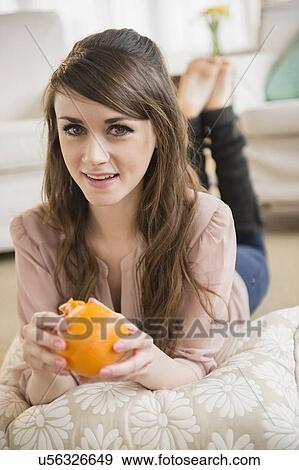Young woman eating orange View Large Photo Image Stock Photo - Young woman eating orange . Fotosearch