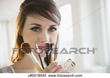 Young woman holding make-up accessories View Large Photo Image Stock Photography - Young woman holding make-up accessories. Fotosearch
