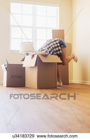 Young woman looking into box in her new house View Large Photo Image Stock Photo - Young woman looking into box in her new house. Fotosearch