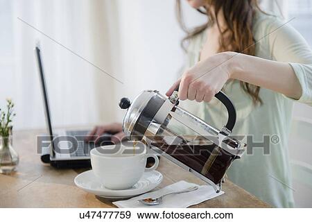 Young woman pouring coffee into cup View Large Photo Image Stock Photo - Young woman pouring coffee into cup. Fotosearch