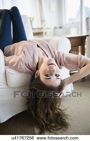 Young woman relaxing on sofa View Large Photo Image Stock Photograph - Young woman relaxing on sofa . Fotosearch