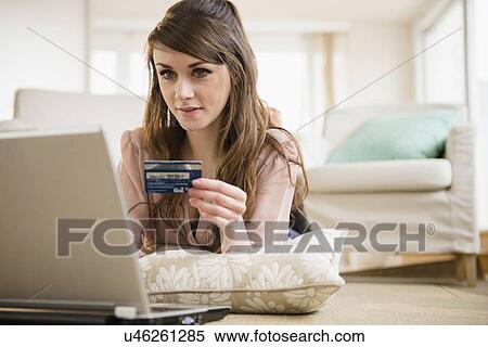 Stock Photography - Young woman shopping online with credit card. Fotosearch