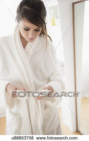 Stock Photo - Young woman wearing white bathrobe. Fotosearch