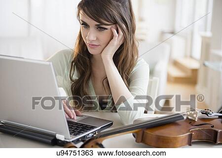 Stock Image - Young woman with laptop. Fotosearch