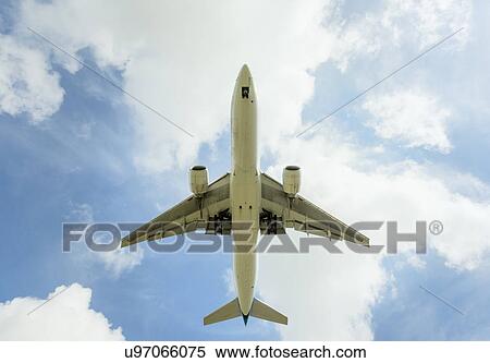 Stock Photography - Aeroplane approaching Amsterdam Airport Schiphol, viewed from below. Fotosearch