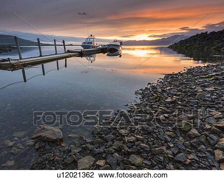 Stock Image - Boats and pier at sunset, Hvalfjordur, Iceland. Fotosearch
