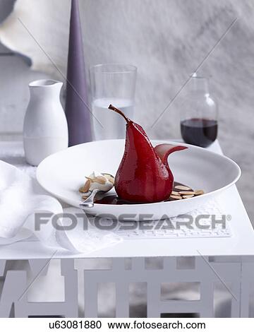 Stock Image - Bowl with pear poached in red wine. Fotosearch