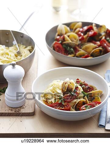 Bowls of fettucine clams with fresh tomatoes and herb garnish View Large Photo Image Picture - Bowls of fettucine clams with fresh tomatoes and herb garnish. Fotosearch