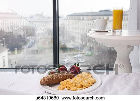 Stock Image - Breakfast of scrambled eggs, juice and coffee by hotel window with view, Vienna, Austria. Fotosearch