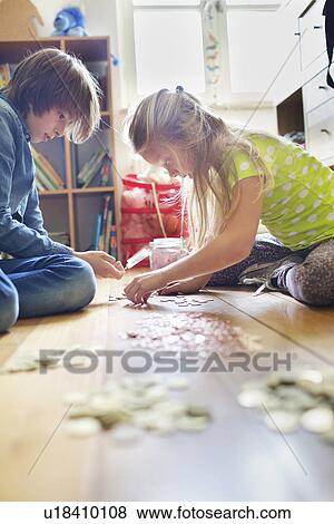 Brother and sister counting coins from savings jar View Large Photo Image Stock Photo - Brother and sister counting coins from savings jar. Fotosearch
