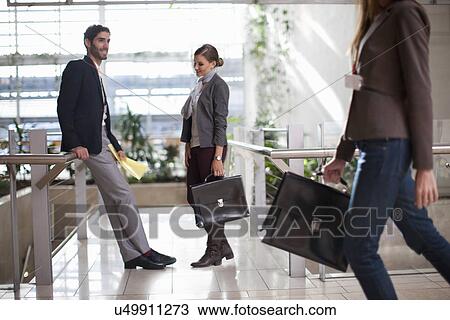 Businessman and businesswomen with briefcases in conference centre atrium View Large Photo Image Stock Image - Businessman and businesswomen with briefcases in conference centre atrium. Fotosearch