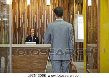 Businessman arriving at office reception View Large Photo Image Stock Photo - Businessman arriving at office reception. Fotosearch