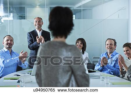 Businessmen and women applauding around boardroom table View Large Photo Image Stock Photography - Businessmen and women applauding around boardroom table. Fotosearch