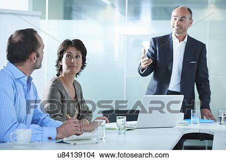 Businessmen and women arguing across boardroom table View Large Photo Image Picture - Businessmen and women arguing across boardroom table. Fotosearch