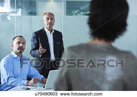 Businessmen and women debating across boardroom table View Large Photo Image Stock Image - Businessmen and women debating across boardroom table. Fotosearch