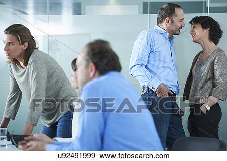 Businessmen and women meeting and chatting informally in office View Large Photo Image Stock Photo - Businessmen and women meeting and chatting informally in office. Fotosearch