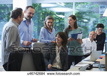 Picture - Businesspeople meeting around desk. Fotosearch