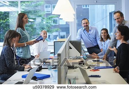 Stock Photo - Businesspeople meeting around desk. Fotosearch