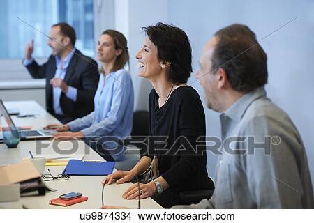 Picture - Businesspeople sitting at desk. Fotosearch