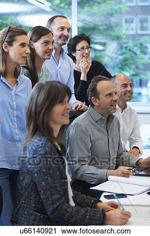 Stock Image - Businesspeople watching presentation. Fotosearch