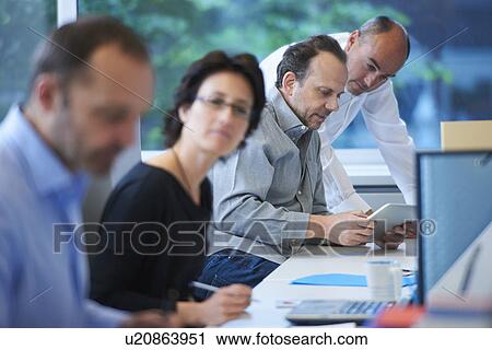 Stock Image - Businesspeople working in office. Fotosearch