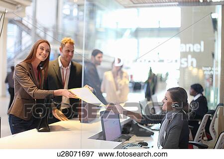 Businesswoman and man checking in at conference centre View Large Photo Image Stock Photo - Businesswoman and man checking in at conference centre. Fotosearch