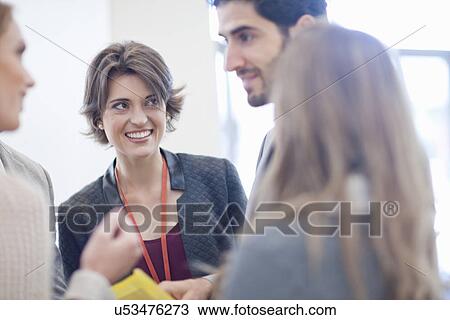 Stock Image - Businesswomen and businessman meeting in conference centre atrium. Fotosearch