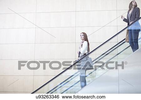 Businesswomen moving down on conference centre elevator View Large Photo Image Stock Photograph - Businesswomen moving down on conference centre elevator. Fotosearch