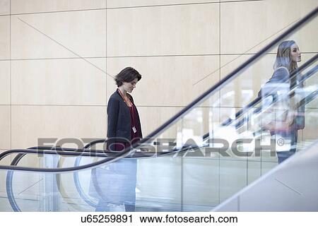 Businesswomen moving up on conference centre elevator View Large Photo Image Stock Image - Businesswomen moving up on conference centre elevator. Fotosearch